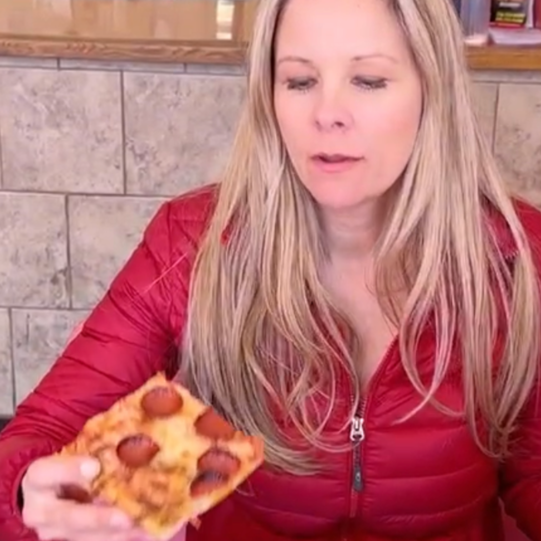 Picture of Julie (PizzaJules) eating a slice of pepperoni pizza.